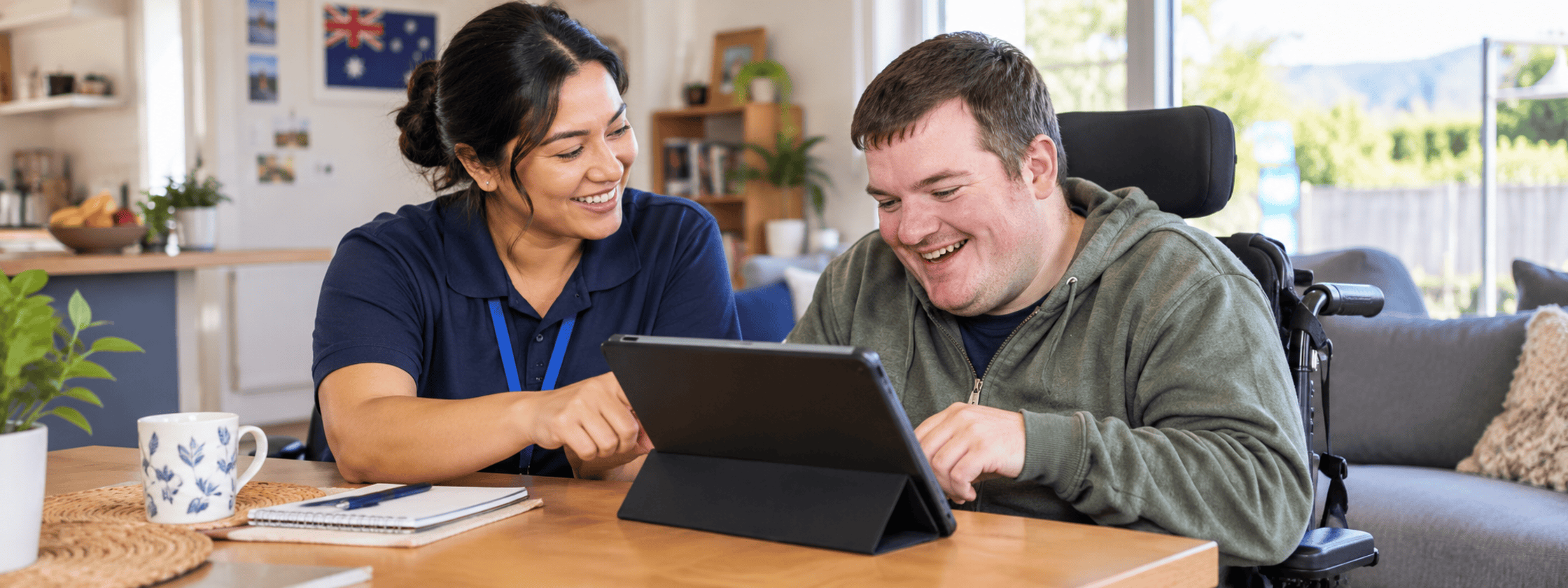 NDIS support worker and participant planning together with a tablet