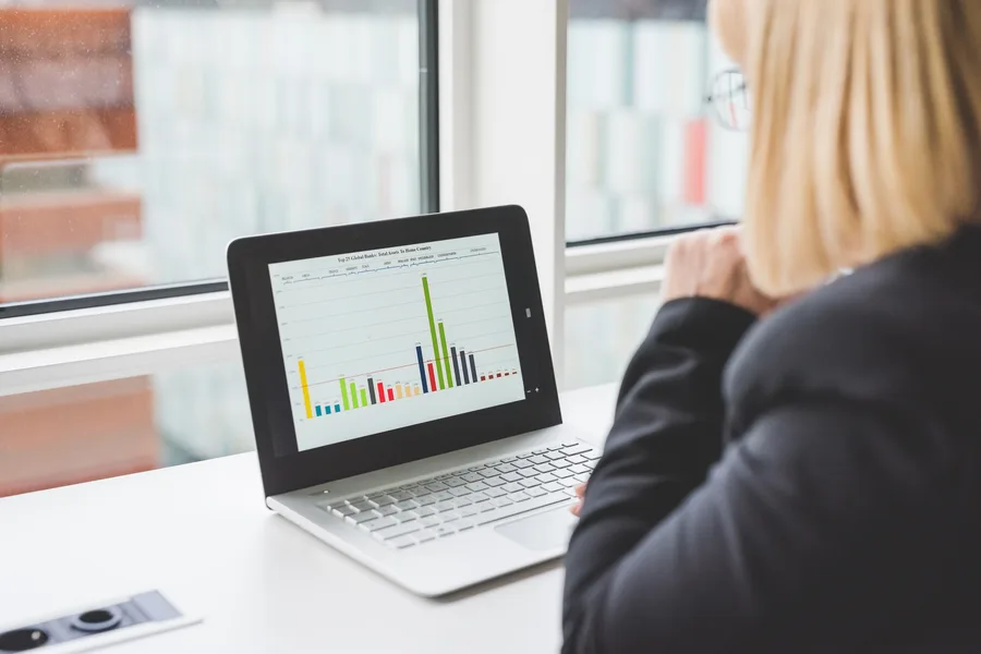 Program manager reviewing a reporting dashboard on a laptop